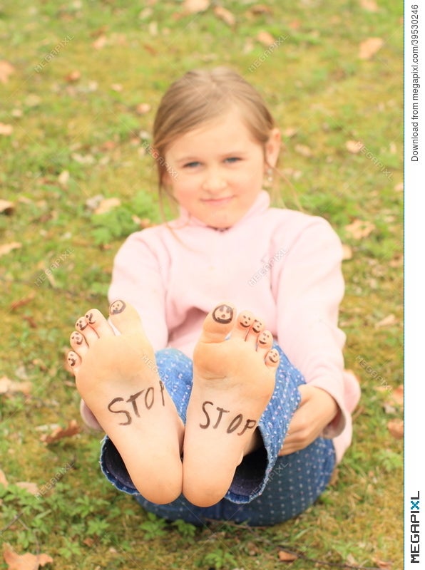 Girl With Smileys On Toes And Sign Stop On Soles Girl With Smileys On Toes And Sign Stop On Soles