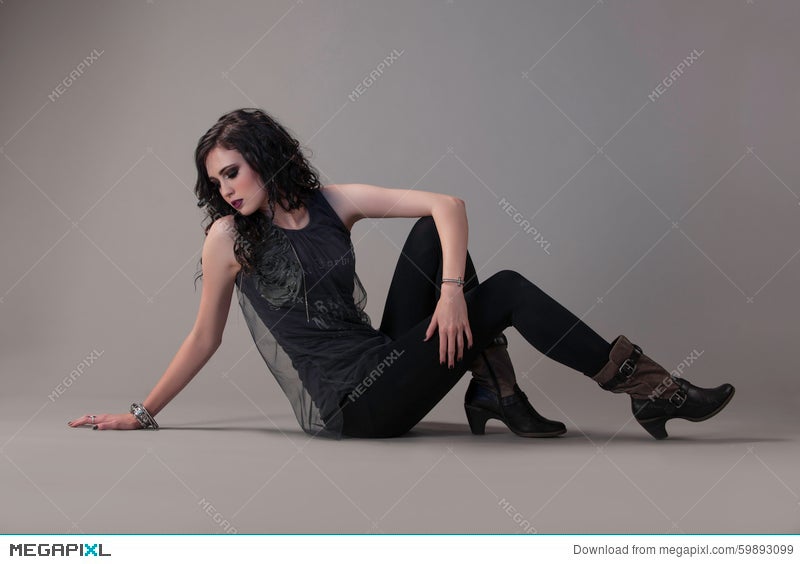 Edgy Rocker Chic Sitting On Floor And Looking Back Stock