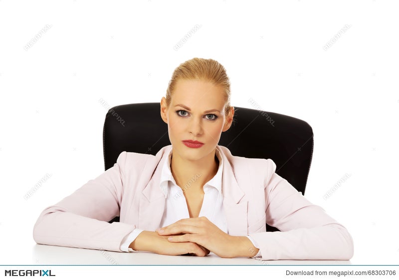 Young Serious Business Woman Sitting Behind The Desk Stock Photo