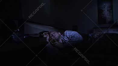 A man goes to sleep in the bedroom at night