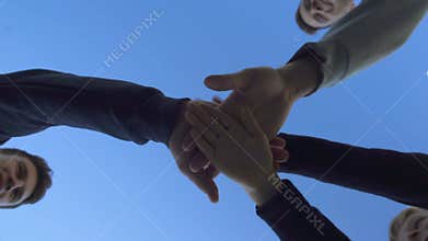 Group of friends put hands together, team work leads to victory, bottom view