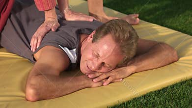 Male enjoying relaxing back massage outdoor.