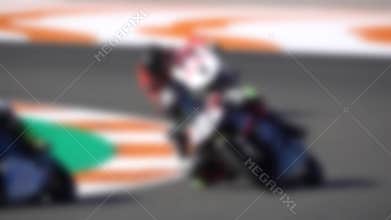Blurred motorbikes competing in a racing circuit and slow-mo