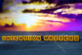 Intention matters on wooden blocks. Cross processed image with bokeh background