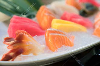 Mixed sliced fish sashimi on ice in white bowl. Sashimi Salmon Tuna Hamachi Prawn and Surf Calm set, raw fish, japanese food in