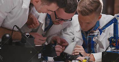 Engineers working on kinetic glove with soldering iron