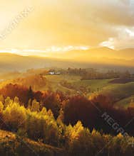 Warm October evening in Transylvania. Magic autumn sunset light over the colored hills