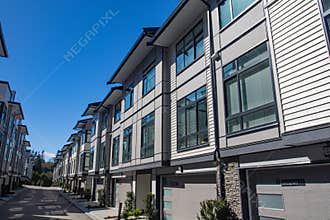 Brand new townhouse complex. Rows of townhomes side by side. External facade of a row of colorful modern urban townhouses. brand n
