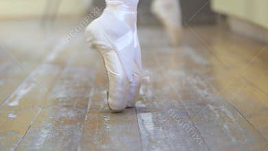 Ballet.Close-up of a girl`s legs in white ballet shoes during ballet training. Element of classical dance. 4K