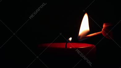 Firing a wax red candle with a match