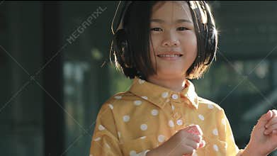 Asian children wearing headphone dancing with happiness face