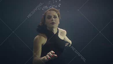 Brunette woman underwater swimming pool on dark background