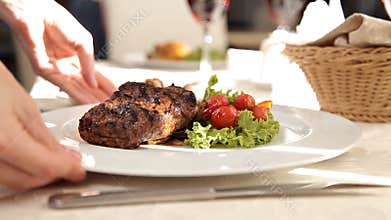 Waiter serving steak in a luxurious restaurant