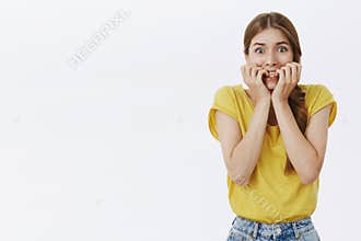Waist-up shot of girl about panic feeling frightened and concerned biting fingers from anxiety and worry popping eyes at