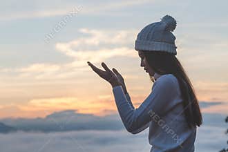 Young christian woman hands open palm up worship and praying to god at sunrise, Christian Religion concept background