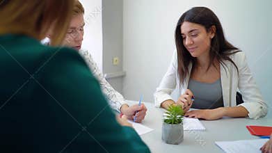 High school student group discussing and solving project assignment at table together