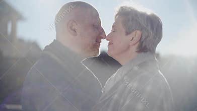 Happy senior couple look at each other, touching noses and old bald man kiss womans forehead with love, passion and
