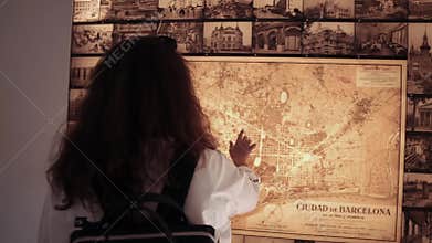 Barcelona, Spain September 2018. Shot from behind of a brunette female tourist standing by the wall map in Park Guell.