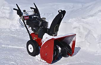 Toro snowblower parked in snow blown driveway