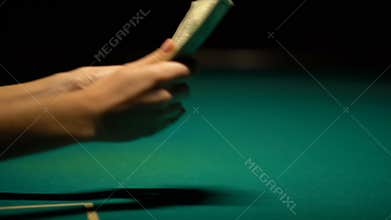 Happy gambler counting money on green table, lucky bet, poker winnings, closeup