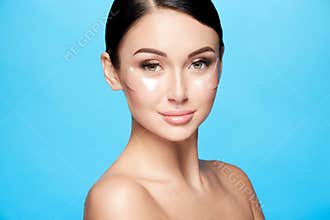 Perfect girl with nude make up and naked shoulders at studio background, invisible eye patches on face, skin care