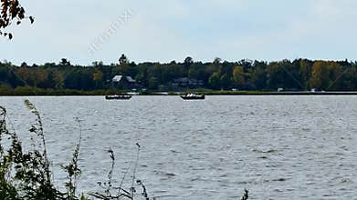 Two fishing boats on a lake in early autumn.