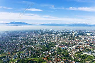 Bandung city with crowd houses at misty morning