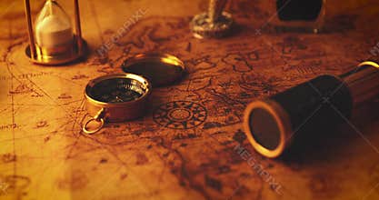 Old nautical navigation items with candle on vintage map