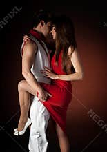 Young couple dancing passion on dark red light