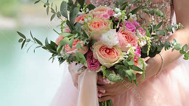Beautiful bridal bouquet in hands of the bride. Wedding bouquet of peach roses by David Austin, single-head pink rose aqua,