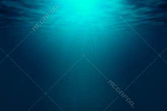 Deep blue sea with rays of sunlight, ocean surface seen from underwater.