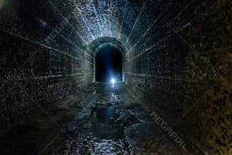 Dark and creepy old historical vaulted flooded underground drainage tunnel