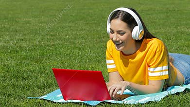 Teenage girl e learning with a laptop on the grass