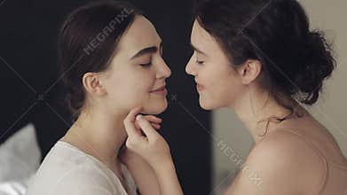 Happy lesbian couple embracing each other and smiling at home face to face in slow motion