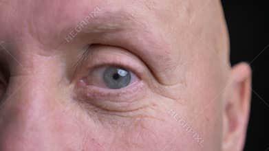 Closeup half-face portrait of middle-aged caucasian man with eye looking straight at camera