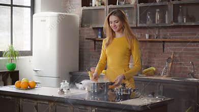Female enjoy cooking lunch in apartment.