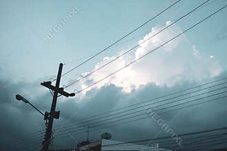 Electricity post and cloudy sky. Low angle view