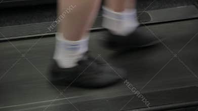 Fat man exercising on the treadmill in the gym.