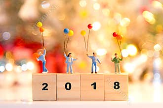 Miniature group happy family holding balloons standing on wooden 2018 with party happy new year,