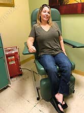 Middle aged woman sits in a chair waiting for blood draw
