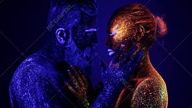 A man and a woman in the ultraviolet light caress each other. Fire and ice, two hypostases.