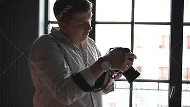 Photographer shoots on his camera near window