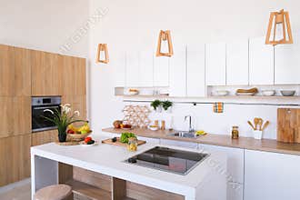 Interior of modern light kitchen with variety of appliances and