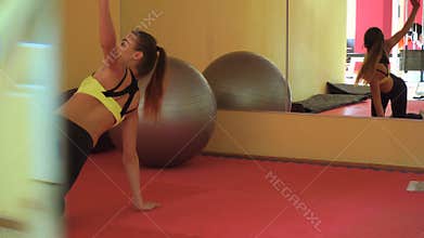 Young slim blonde sports girl training in a gym