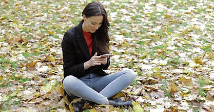 Woman using smartphone on grass
