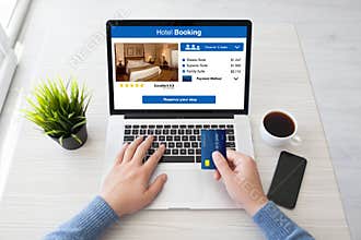 Man hands holding credit card laptop with app hotel booking