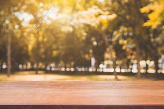 Wooden board empty table in front of blurred background. Perspective brown wood table over blur trees in forest background