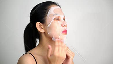 Young woman doing facial mask sheet