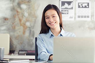 New generation asian business woman using laptop at office