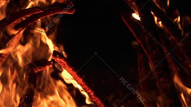 Ultra slow motion shot of fire flames and glowing ashes on black background